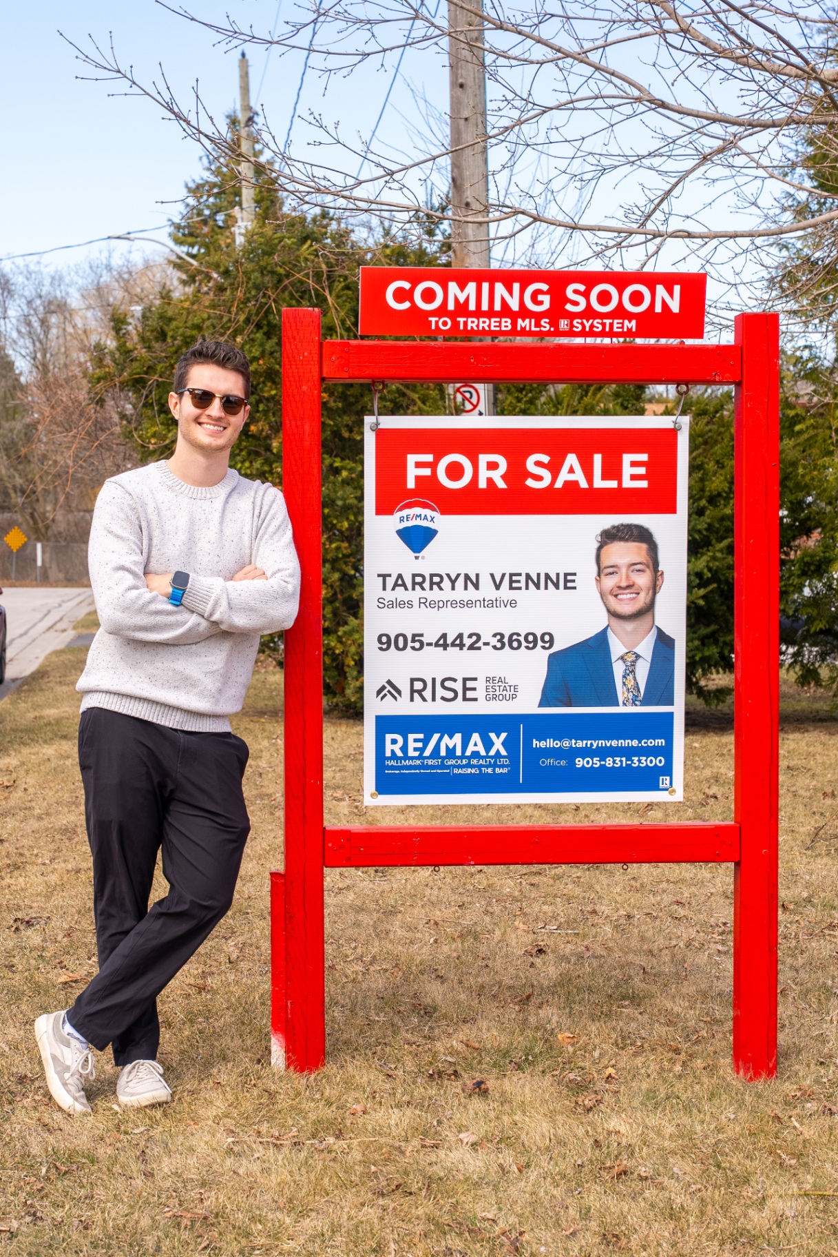Tarryn Venne next to a RE/MAX For Sale sign in Durham Region